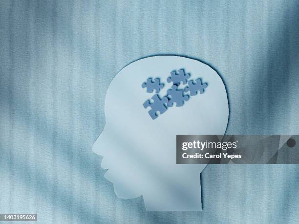 paper head with puzzle pieces-autism concept.purple paper work background - remembrance imagens e fotografias de stock