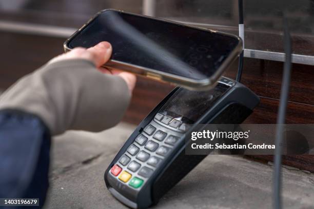 new problems, city life is expensive, contactless payment method with smartphone nfc and banking electronic card - man check suit stock-fotos und bilder