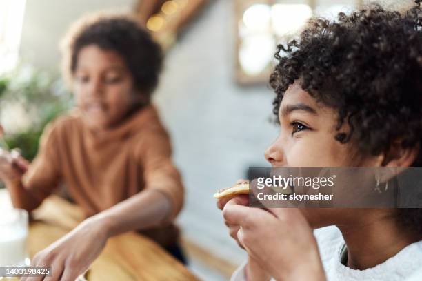 cute black girl eating pancake at home. - pannenkoek stockfoto's en -beelden