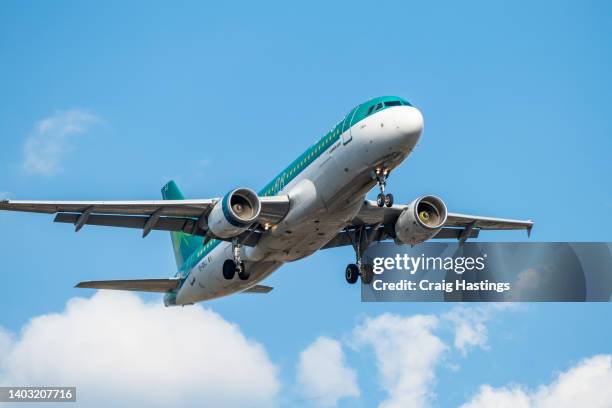 air lingus flight flying low over the houses of a residential estate in london in its approach into lhr london heathrow airport on a sunny but cloudy day. - a320 turbine engine stock pictures, royalty-free photos & images