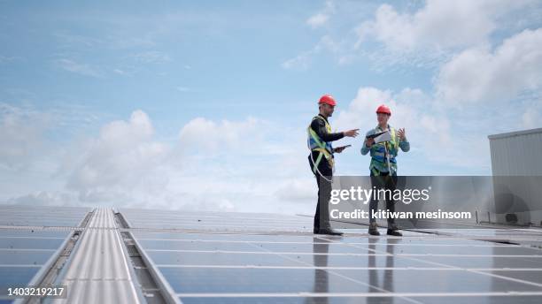 team industrial engineer or professionals technicians working plant generate electricity from solar energy. discuss about installing system and maintenance plan of solar panel on the roof of factory. - roof installation stock pictures, royalty-free photos & images