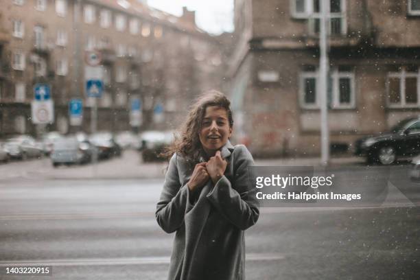 portrait of young woman shivering from winter in rainy day in the street. - women shower stock-fotos und bilder
