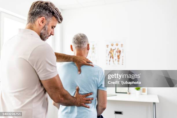homme mûr ayant un ajustement chiropratique du dos. - kinésithérapie photos et images de collection