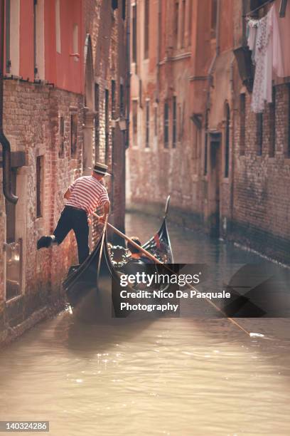 gondolier riding gondola in venice - venice gondola stock pictures, royalty-free photos & images