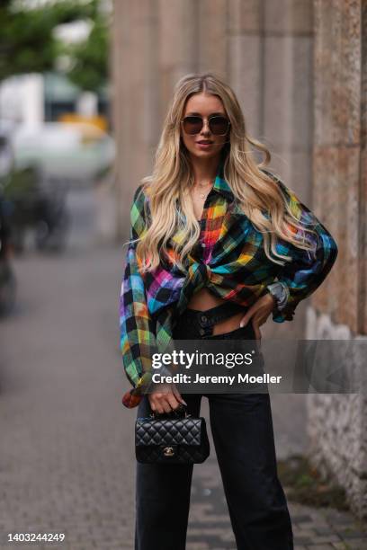 Scarlett Gartmann-Reus seen wearing a black sunglasses from Mister Spex x Scarlett Gartmann, a colorful flannel blouse shirt from R13, a black denim...