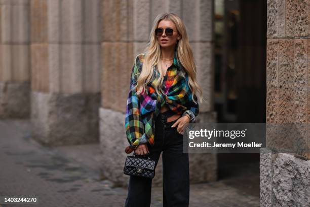 Scarlett Gartmann-Reus seen wearing a black sunglasses from Mister Spex x Scarlett Gartmann, a colorful flannel blouse shirt from R13, a black denim...