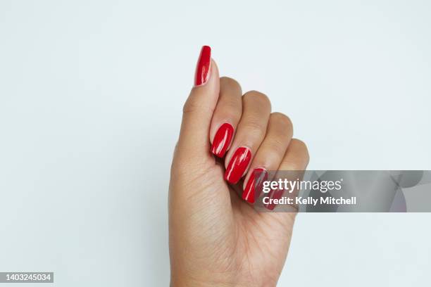 black woman manicured hand with red nail polish on white background - red nail polish stockfoto's en -beelden