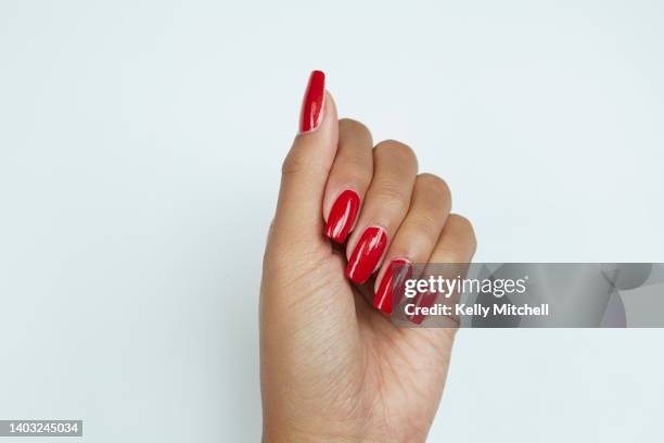 black woman manicured hand with red nail polish on white background - african american nails stock pictures, royalty-free photos & images