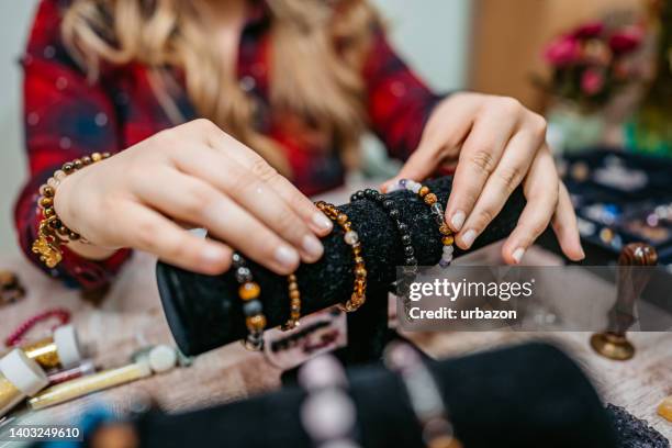 young woman displaying bead bracelets - making jewelry stockfoto's en -beelden