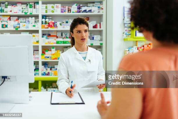 pharmacist and customer talking about prescription - pharmacist and patient imagens e fotografias de stock