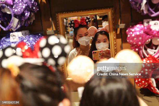 Tourists shop at the World of Disney Store on June 16, 2022 in Shanghai, China. Shanghai Disneytown and Shanghai Disneyland Hotel resumed operations...