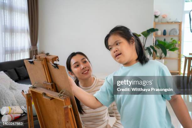 down syndrome painting on canvas with his tutor - international day two stock pictures, royalty-free photos & images