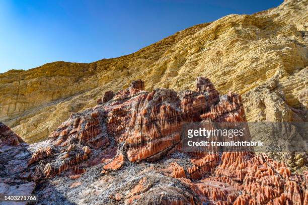 red salt rock and yellow mountain face - rock salt stockfoto's en -beelden