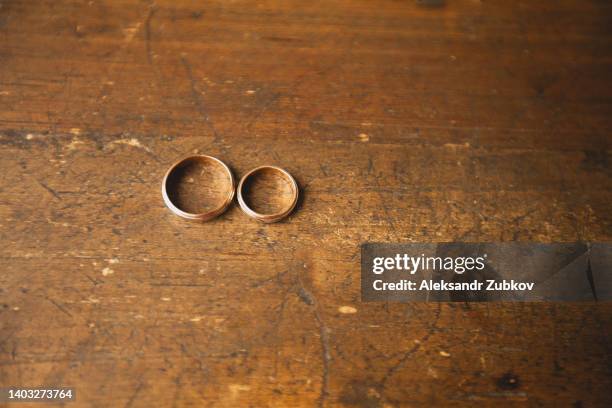 gold wedding rings of the bride and groom on an old wooden chest of drawers, table or bedside table. wedding day. - wedding ring stock pictures, royalty-free photos & images