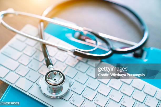 medical stethoscope on keyboard - stethoscope fotografías e imágenes de stock