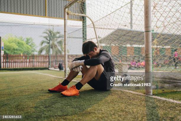 mid adult male footballer dribbling around opponent - soccer goalkeeper stock pictures, royalty-free photos & images