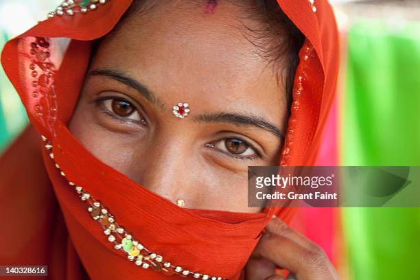 close up of woman wearing sari. - woman in red sari stock-fotos und bilder