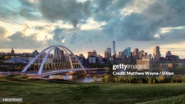 view of bridge over river against cloudy sky,edmonton,alberta,canada - edmonton stock pictures, royalty-free photos & images
