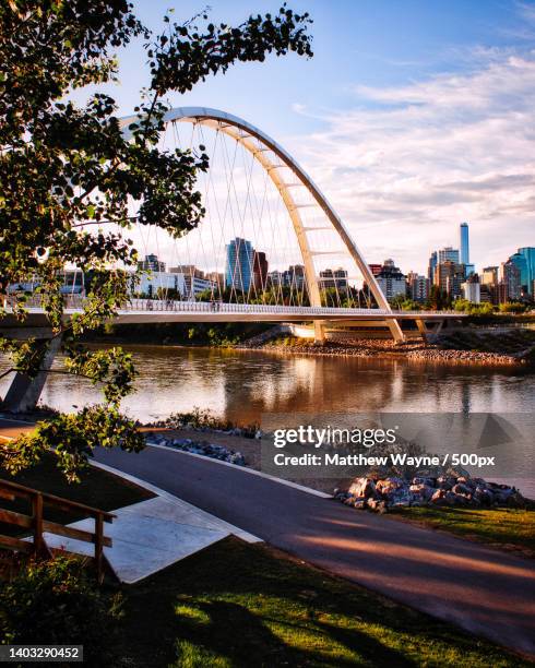 view of bridge over river against cloudy sky,edmonton,alberta,canada - edmonton fotografías e imágenes de stock