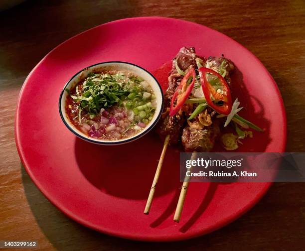 Nuea Yang Pao Taan - Korat wagyu beef skewers on Binchotan charcoal, broken rice and a tamarind dip at Praca, the Thai style izakaya and beachfront...