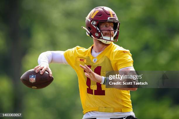 Carson Wentz of the Washington Commanders participates in a drill during the organized team activity at INOVA Sports Performance Center on June 16,...