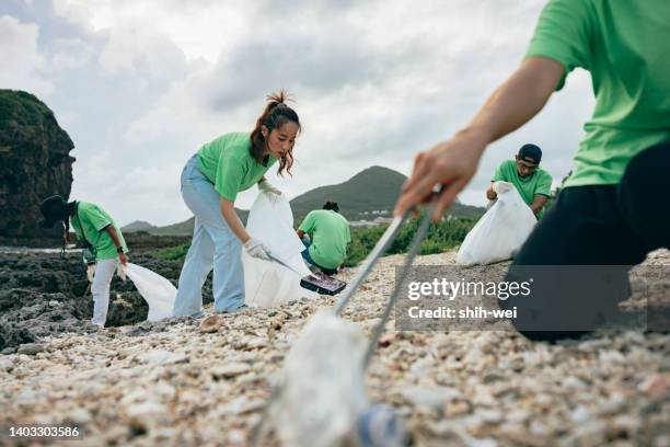 community volunteer groups on the beach - global charity initiative stock pictures, royalty-free photos & images
