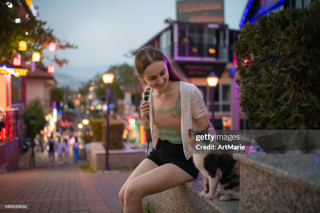 Young woman meeting a cat while traveling in Turkey