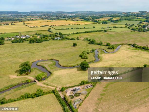 sewage processing plant next to a meandering river in devon - england river landscape stock pictures, royalty-free photos & images
