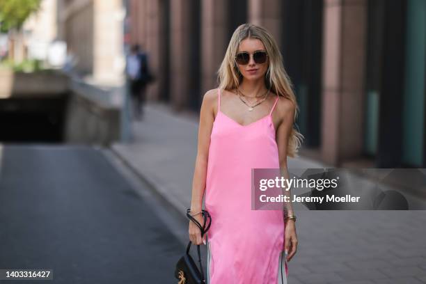 Scarlett Gartmann-Reus seen wearing a black sunglasses, a pink midi dress from Palm Angels and a black leather handbag from Palm Angels on June 13,...