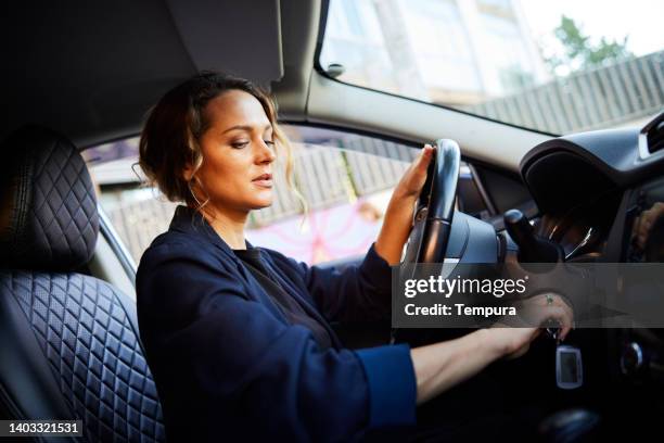 eine geschäftsfrau in einem auto startet den motor. - zündschloß stock-fotos und bilder