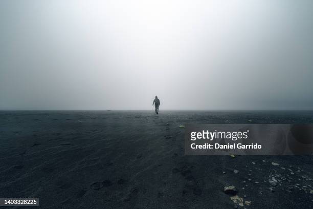 walking alone into the fog, walking into nothingness, fog in iceland, loneliness - paysage volcanique photos et images de collection