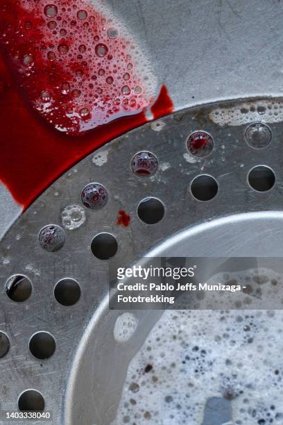 soap bubbles and and blood color ink - blood in sink stockfoto's en -beelden