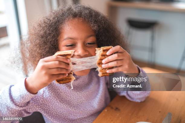 cute and playful girl eating a cheese sandwich - cheese stock pictures, royalty-free photos & images