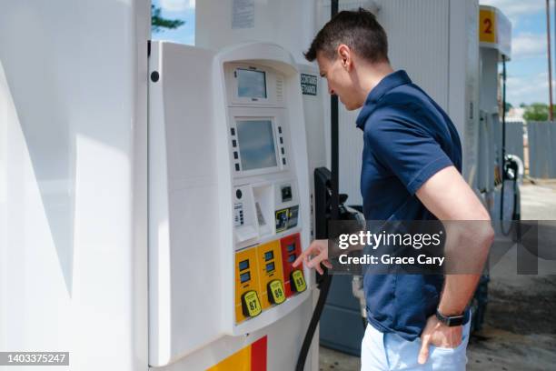 man purchases gas at pump amid skyrocketing prices - petrol paying ストックフォト��と画像