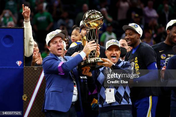 Owners Joe Lacob and Peter Guber of the Golden State Warriors raise the Larry O'Brien Championship Trophy after defeating the Boston Celtics 103-90...