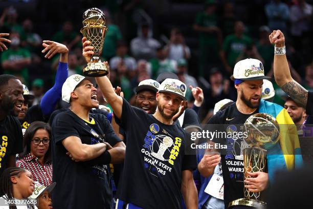 Stephen Curry of the Golden State Warriors raises the Bill Russell NBA Finals Most Valuable Player Award after defeating the Boston Celtics 103-90 in...