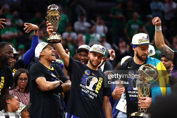 Stephen Curry of the Golden State Warriors raises the Bill Russell NBA Finals Most Valuable Player Award after defeating the Boston Celtics 103-90 in...