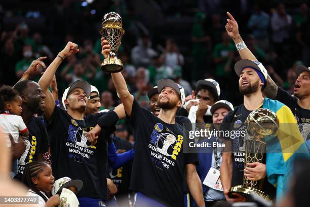 Stephen Curry of the Golden State Warriors raises the Bill Russell NBA Finals Most Valuable Player Award after defeating the Boston Celtics 103-90 in...