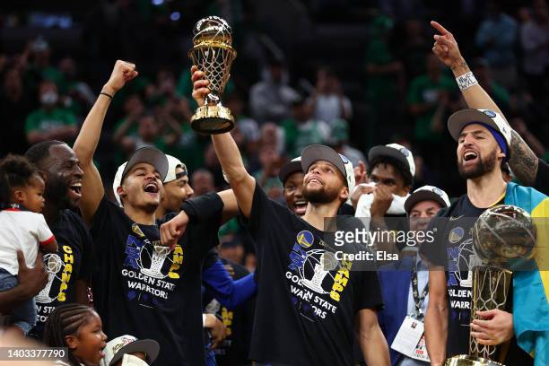 Stephen Curry of the Golden State Warriors raises the Bill Russell NBA Finals Most Valuable Player Award after defeating the Boston Celtics 103-90 in...