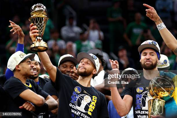 Stephen Curry of the Golden State Warriors raises the Bill Russell NBA Finals Most Valuable Player Award after defeating the Boston Celtics 103-90 in...