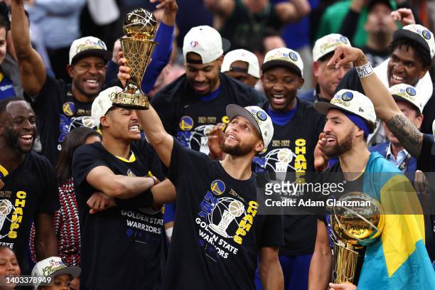 Stephen Curry of the Golden State Warriors raises the Bill Russell NBA Finals Most Valuable Player Award after defeating the Boston Celtics 103-90 in...