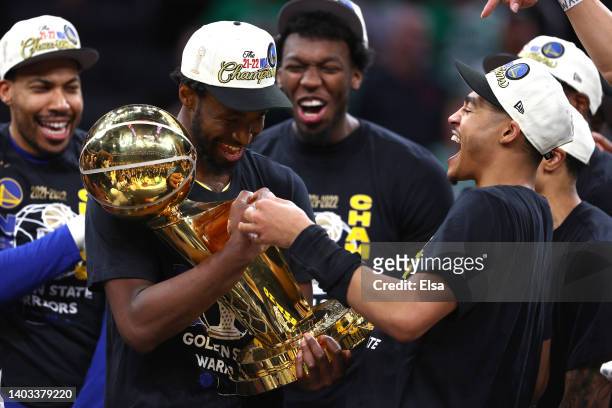 Andrew Wiggins and Jordan Poole of the Golden State Warriors celebrates with the Larry O'Brien Championship Trophy after defeating the Boston Celtics...