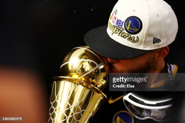 Stephen Curry of the Golden State Warriors celebrates with the Bill Russell NBA Finals Most Valuable Player Award after defeating the Boston Celtics...