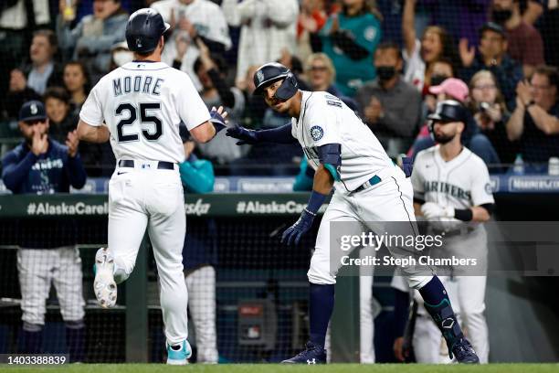 Dylan Moore and Julio Rodriguez of the Seattle Mariners celebrate a run against the Los Angeles Angels during the eighth inning at T-Mobile Park on...