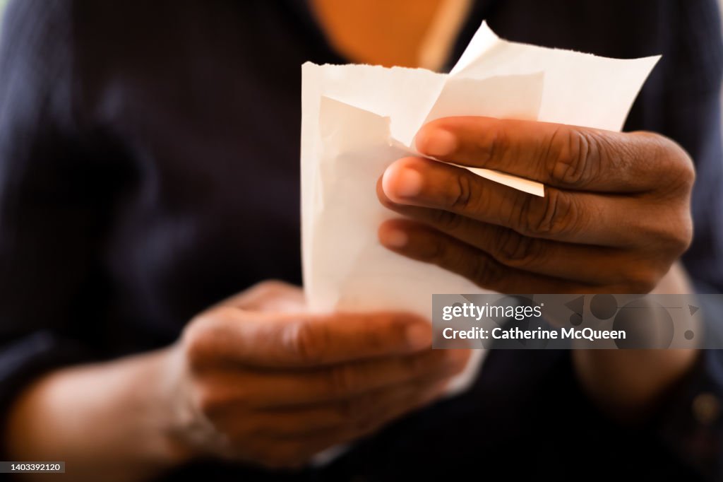 Economy: black woman holding multiple retail receipts