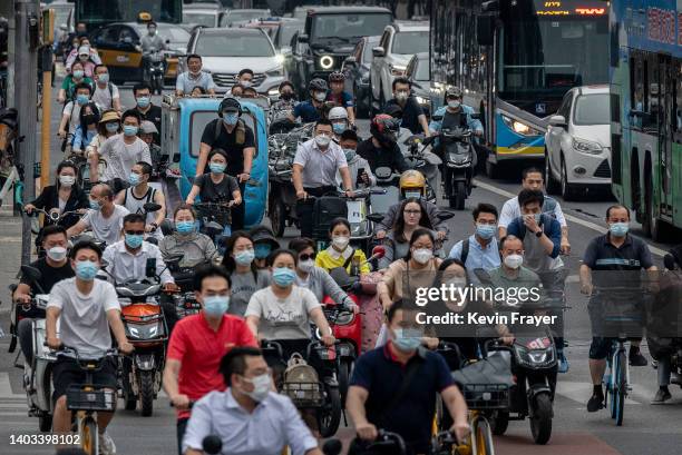 Commuters, many wearing protective masks, are seen in heavy traffic during rush hour at an intersection on June 16, 2022 in Beijing, China. China's...