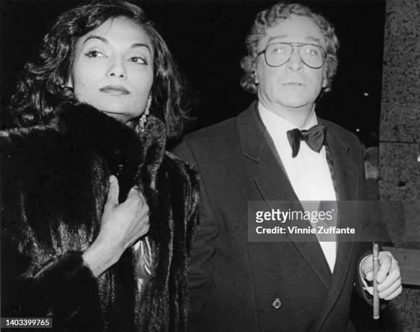 Guyanese actress and fashion model Shakira Caine, wearing a fur coat, and her husband, British actor Michael Caine, in a tuxedo, attend an event,...