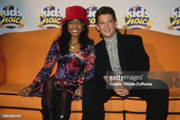 American actress and singer Tatyana Ali and American actor Brandon Call sitting on an orange sofa in the press room of the 1992 Nickelodeon Kids'...