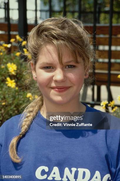 America child actress Candace Cameron, wearing a blue t-shirt with 'Candace' printed in white, with her plaited hair over her shoulder, United...