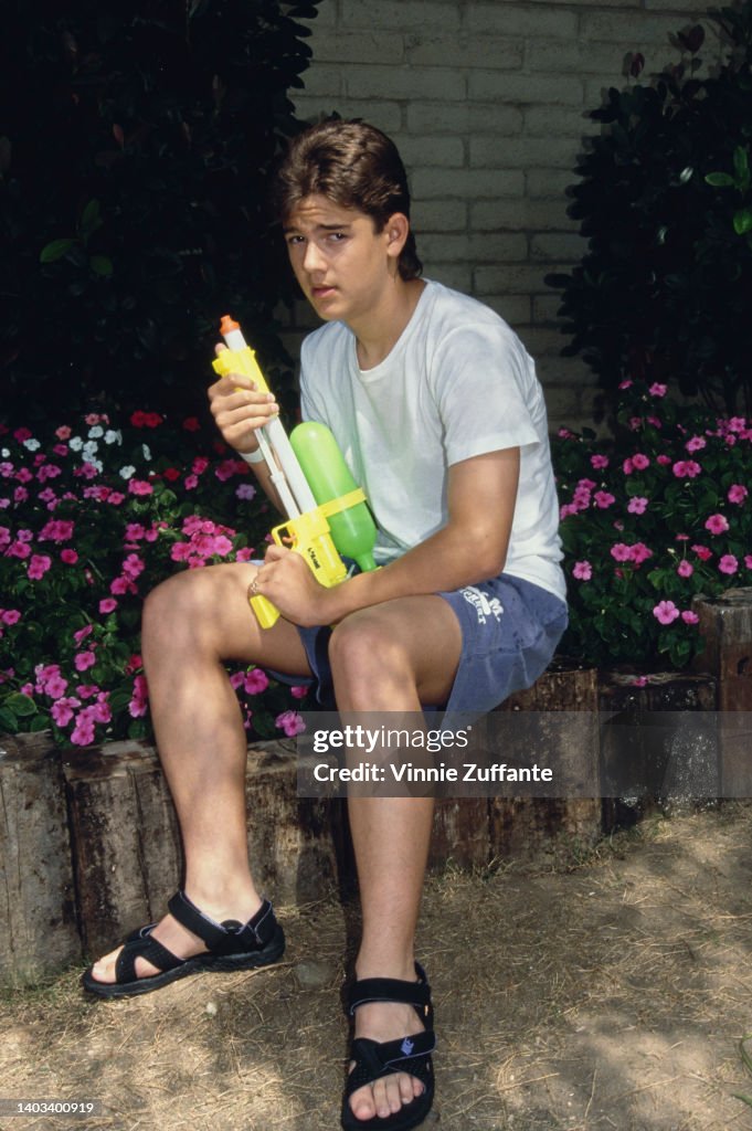 America child actor Brandon Call, wearing a white t-shirt and blue ...